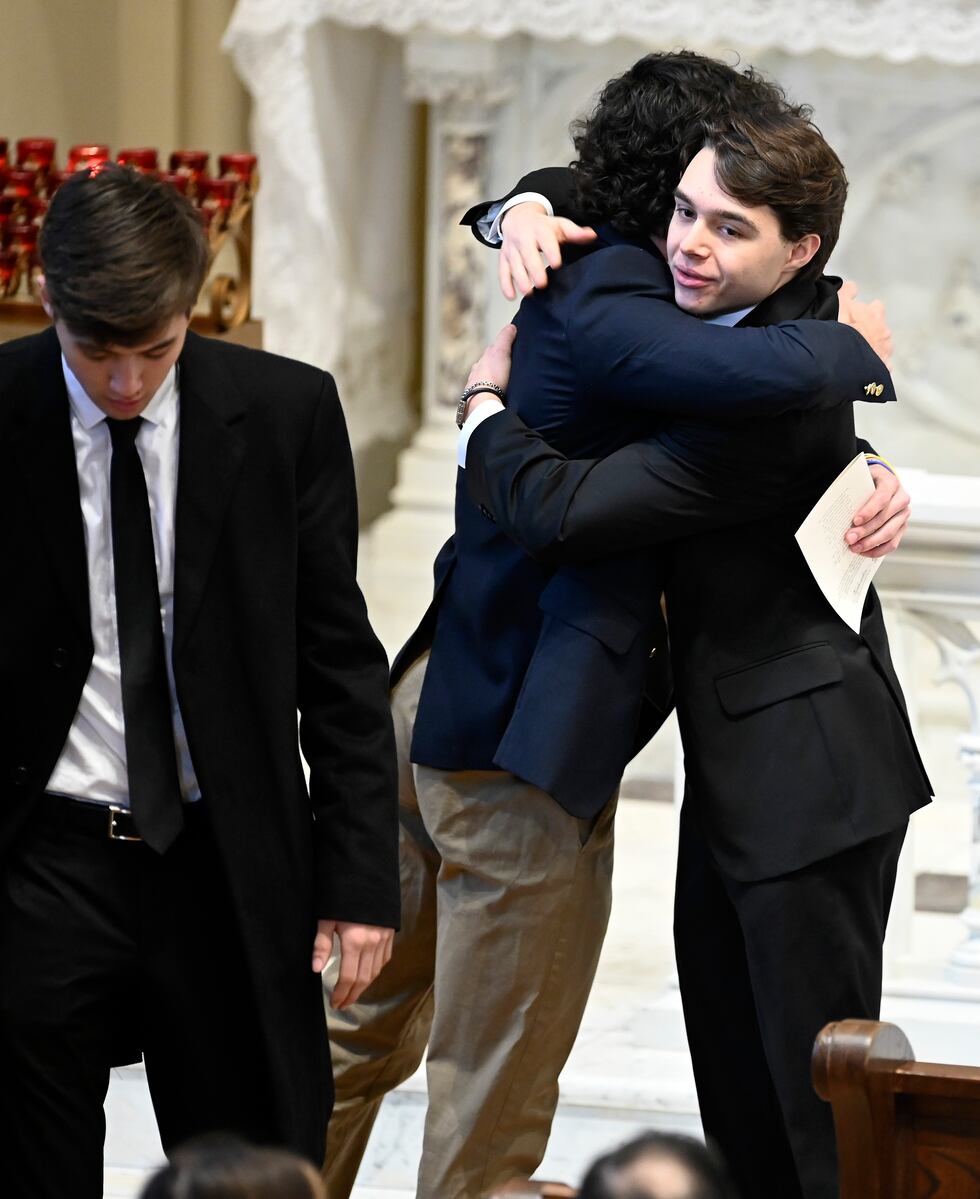 Family members friends and supporters console each other during the funeral mass for Brian...