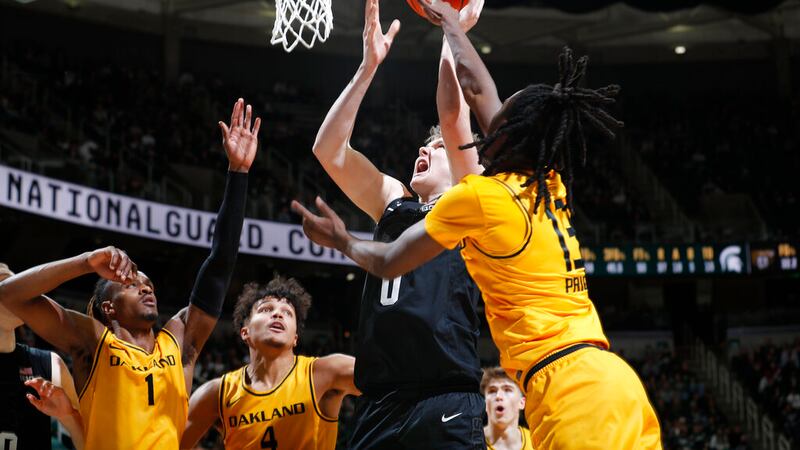 Michigan State's Jaxon Kohler, center, shoots against Oakland's Osei Price, right, Keaton...
