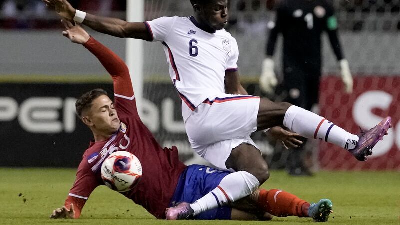 Costa Rica's Brandon Aguilera, below, and United States' Yunus Musah battle for the ball...