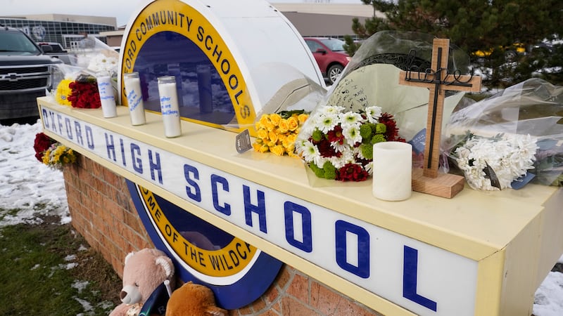 FILE - Memorial items are shown on the sign of Oxford High School in Oxford, Mich., Wednesday,...