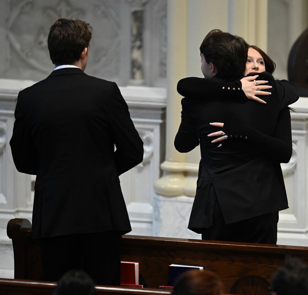 Family members friends and supporters console each other during the funeral mass for Brian...
