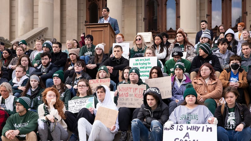 FILE - Protesters hold signs to protest gun violence at a student sit in at the Michigan state...